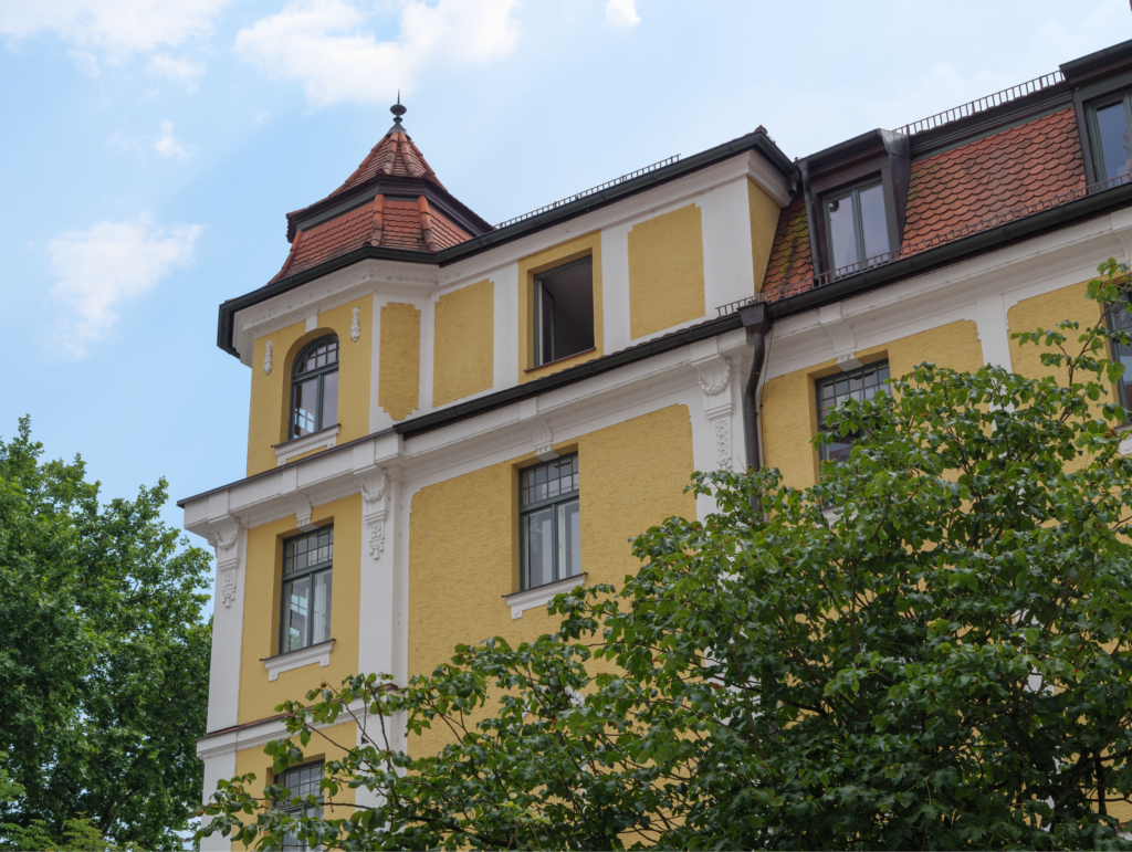 Dieses Bild dient nur als ein Symbol für das Thema Wohnen. Klicken Sie darauf, wenn Sie zum Menüpunkt Wohnen springen möchten. Auf dem Bild ist ein hohes, gelbes Haus zu sehen. Vor dem Haus sind grüne Bäume zu sehen.